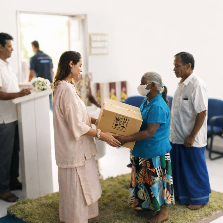 A guest handing a boxed water filter to a woman as two men look on